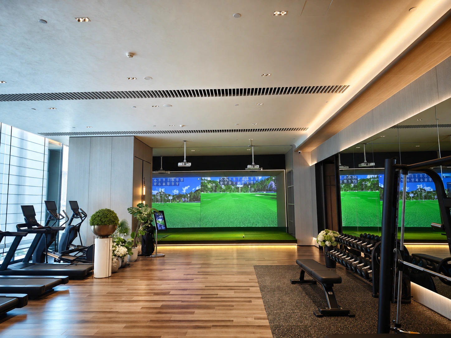 Retouched gym interior showing a golf simulator alongside treadmills and strength equipment