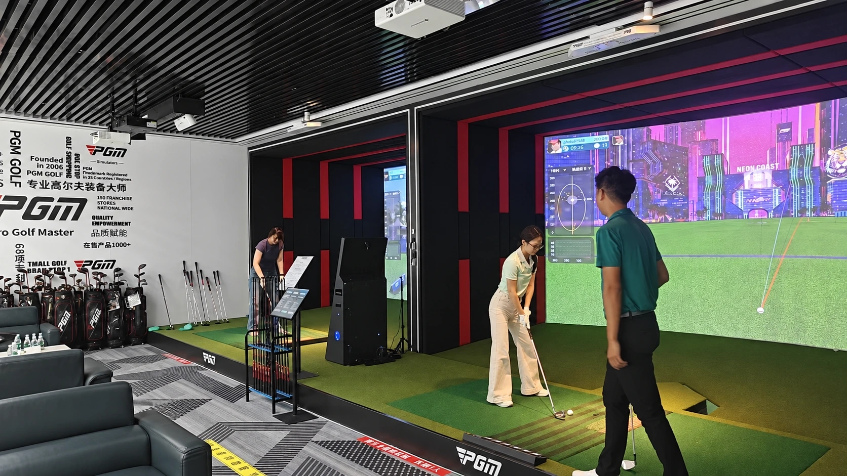 Retouched PGM multi-bay showroom retaining three people in the hitting areas with empty lounge seating